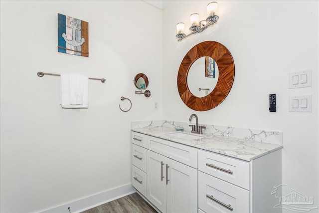 bathroom with wood finished floors, vanity, and baseboards