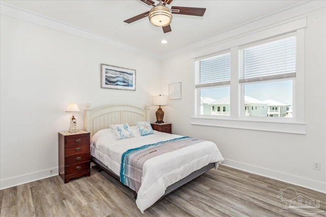 bedroom with baseboards, a ceiling fan, ornamental molding, wood finished floors, and recessed lighting