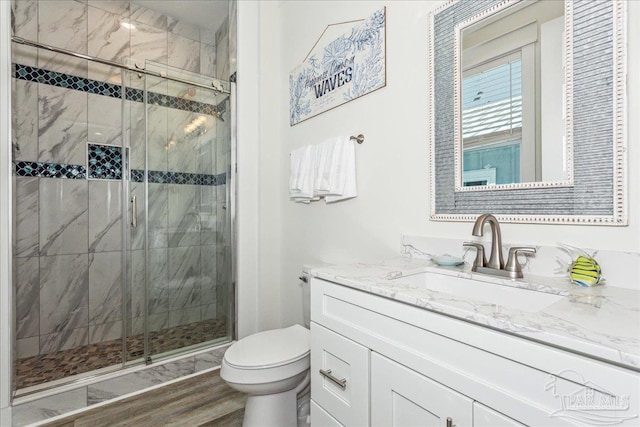 full bathroom with wood finished floors, vanity, toilet, and a shower stall