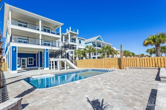 view of swimming pool with stairway, a patio area, fence, and a fenced in pool