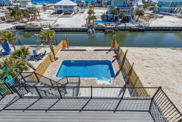 outdoor pool with a patio and a water view