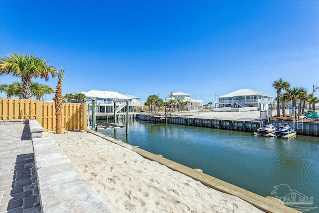 view of dock with a water view and fence