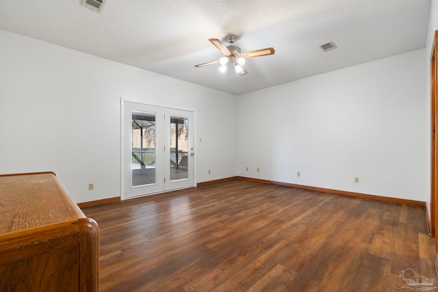 spare room with ceiling fan, a textured ceiling, dark hardwood / wood-style flooring, and french doors