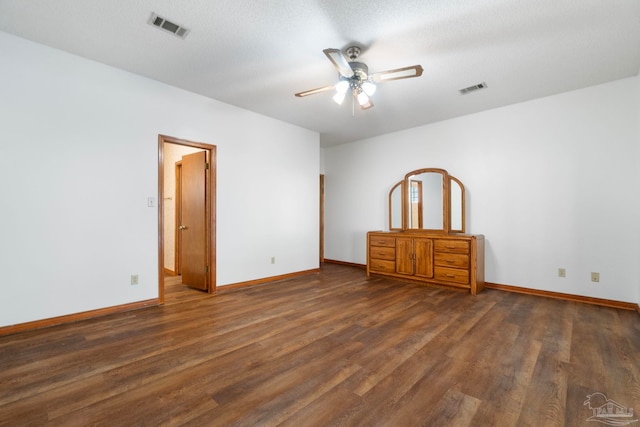 unfurnished bedroom with ceiling fan, a textured ceiling, and dark hardwood / wood-style flooring