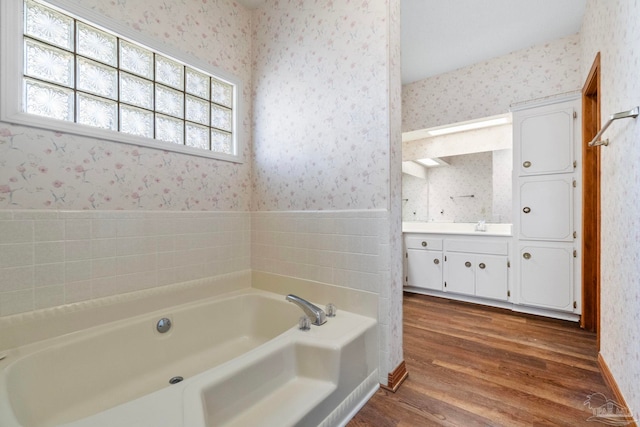 bathroom with a bath, wood-type flooring, and vanity