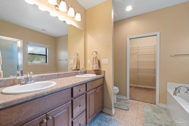 bathroom featuring tiled bath, toilet, tile patterned floors, and vanity