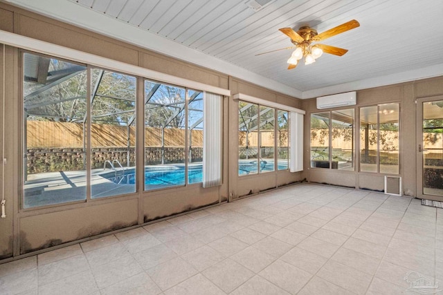 unfurnished sunroom featuring an AC wall unit, plenty of natural light, and ceiling fan