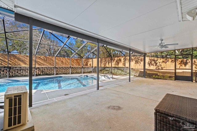 view of swimming pool with ceiling fan, a patio area, and a lanai