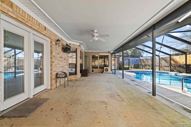 view of swimming pool with glass enclosure, a patio area, and ceiling fan