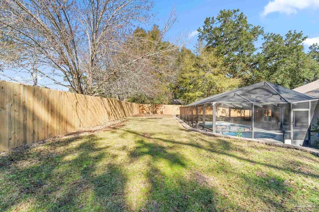 view of yard with a fenced in pool and glass enclosure