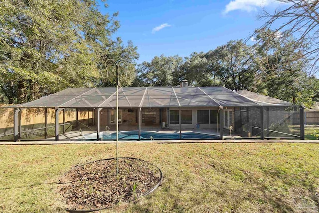 back of house with a lanai and a yard