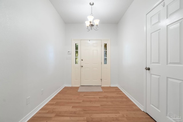 foyer featuring light wood-type flooring and a notable chandelier