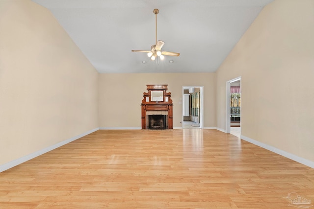 unfurnished living room with light hardwood / wood-style floors, lofted ceiling, ceiling fan, and a fireplace