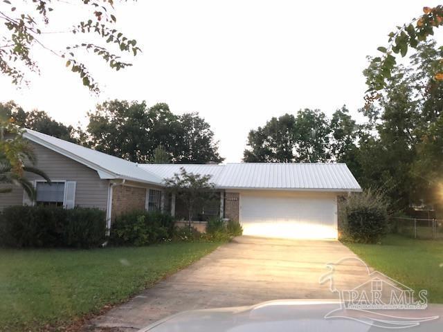 single story home with a garage and a front lawn