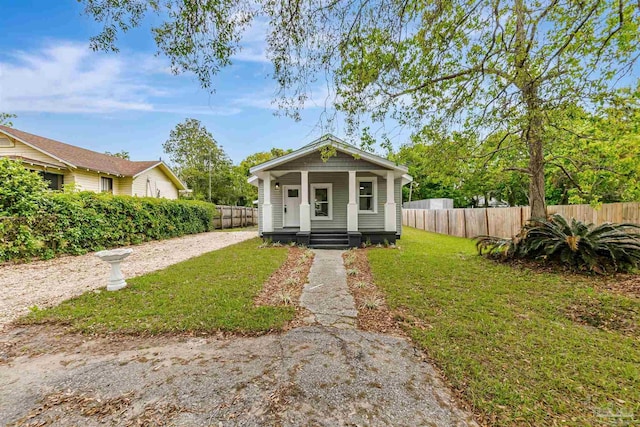 214 Thayer Ave, Pensacola, FL 32507 - shotgun-style home with a front lawn, fence, and covered porch