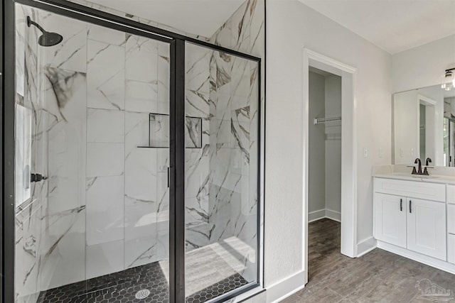 214 Thayer Ave, Pensacola, FL 32507 - bathroom with baseboards, a spacious closet, vanity, wood finished floors, and a marble finish shower