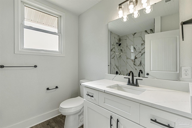 214 Thayer Ave, Pensacola, FL 32507 - full bathroom with baseboards, toilet, vanity, wood finished floors, and a marble finish shower