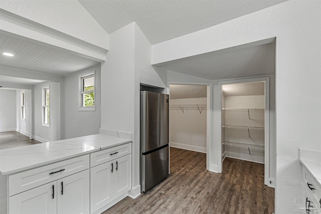 214 Thayer Ave, Pensacola, FL 32507 - kitchen with light stone counters, a peninsula, white cabinetry, freestanding refrigerator, and dark wood-type flooring