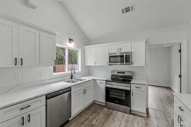 214 Thayer Ave, Pensacola, FL 32507 - kitchen with white cabinets, visible vents, appliances with stainless steel finishes, a sink, and lofted ceiling