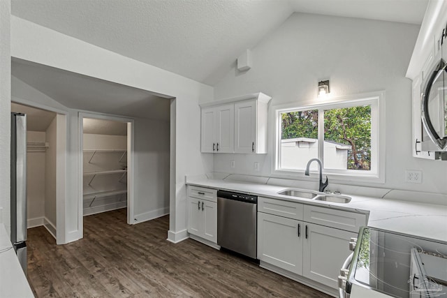 214 Thayer Ave, Pensacola, FL 32507 - kitchen featuring white cabinets, a sink, dark wood-style flooring, stainless steel appliances, and lofted ceiling