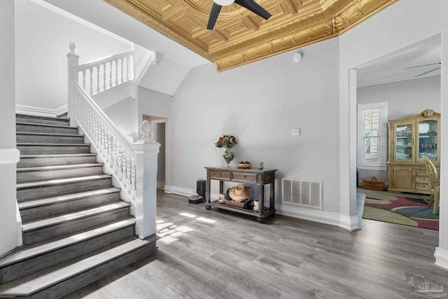 staircase featuring crown molding, ceiling fan, and hardwood / wood-style flooring