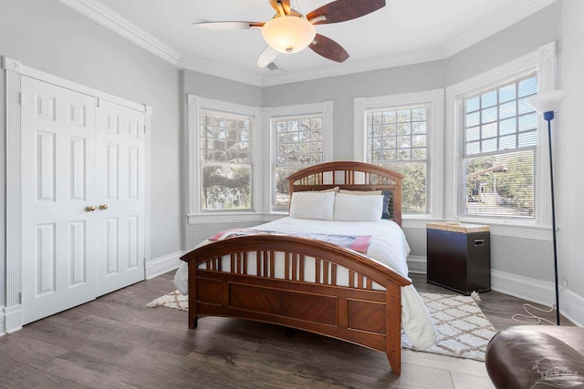 bedroom with ceiling fan, ornamental molding, a closet, and dark wood-type flooring