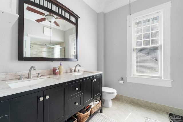 bathroom with a shower with door, crown molding, ceiling fan, vanity, and toilet