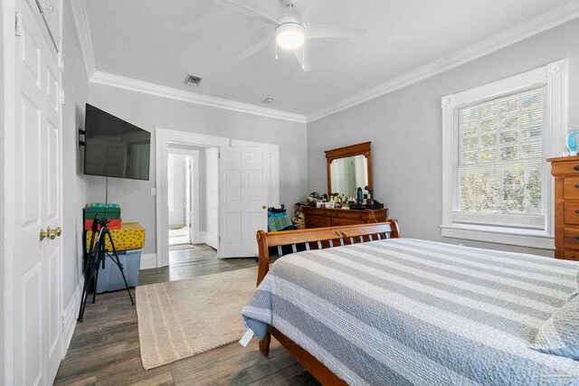 bedroom featuring ceiling fan, dark wood-type flooring, and crown molding