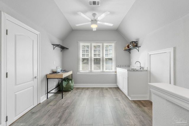 laundry room with ceiling fan, light hardwood / wood-style flooring, and sink