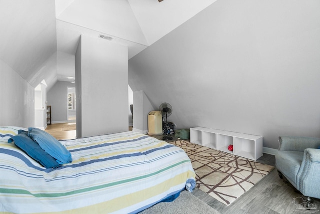 bedroom featuring light hardwood / wood-style flooring and lofted ceiling