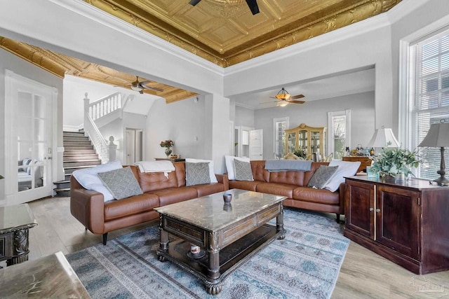 living room with ornamental molding, light hardwood / wood-style floors, and ceiling fan