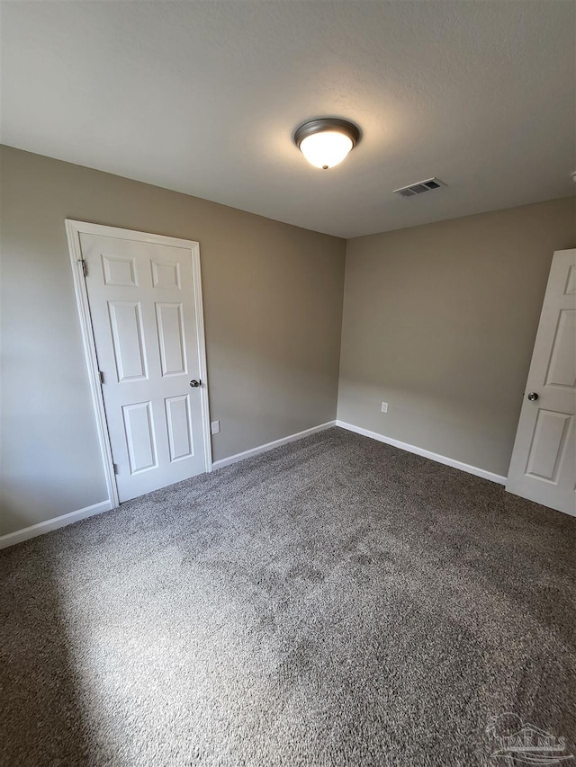 spare room featuring a textured ceiling and carpet floors