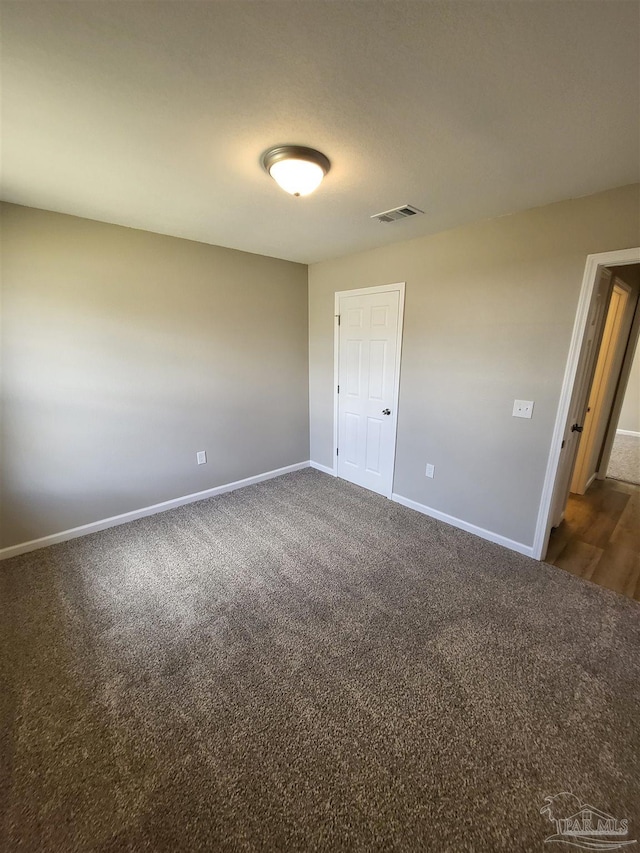 unfurnished bedroom featuring dark carpet