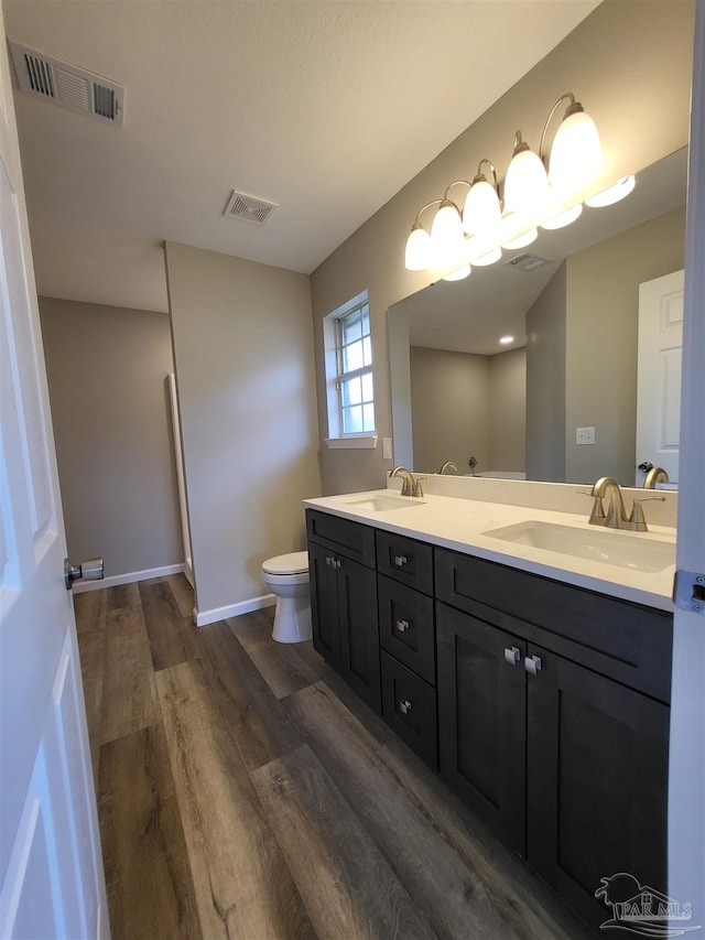 bathroom with vanity, toilet, and hardwood / wood-style flooring