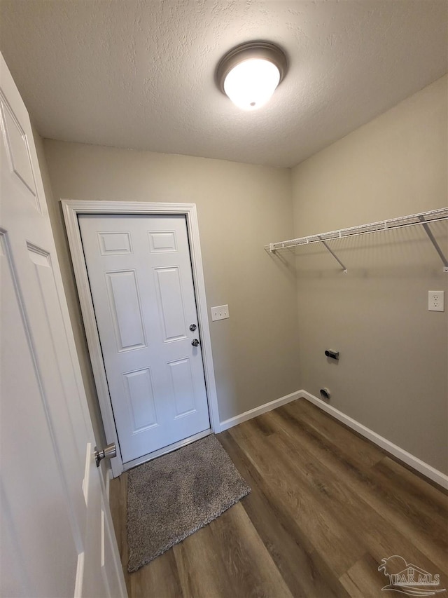 laundry room featuring hookup for an electric dryer, dark wood-type flooring, and a textured ceiling