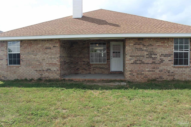 back of property featuring a lawn