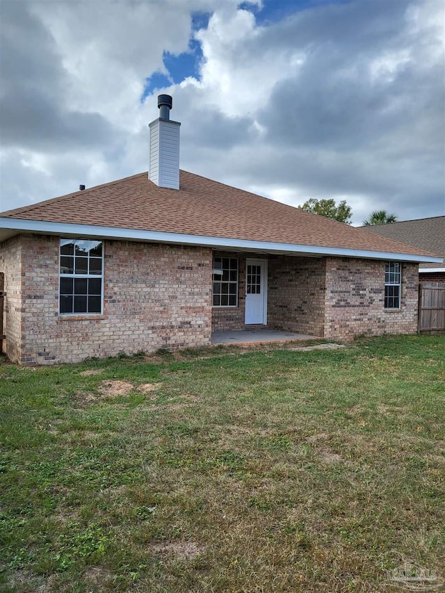 back of house featuring a patio and a lawn