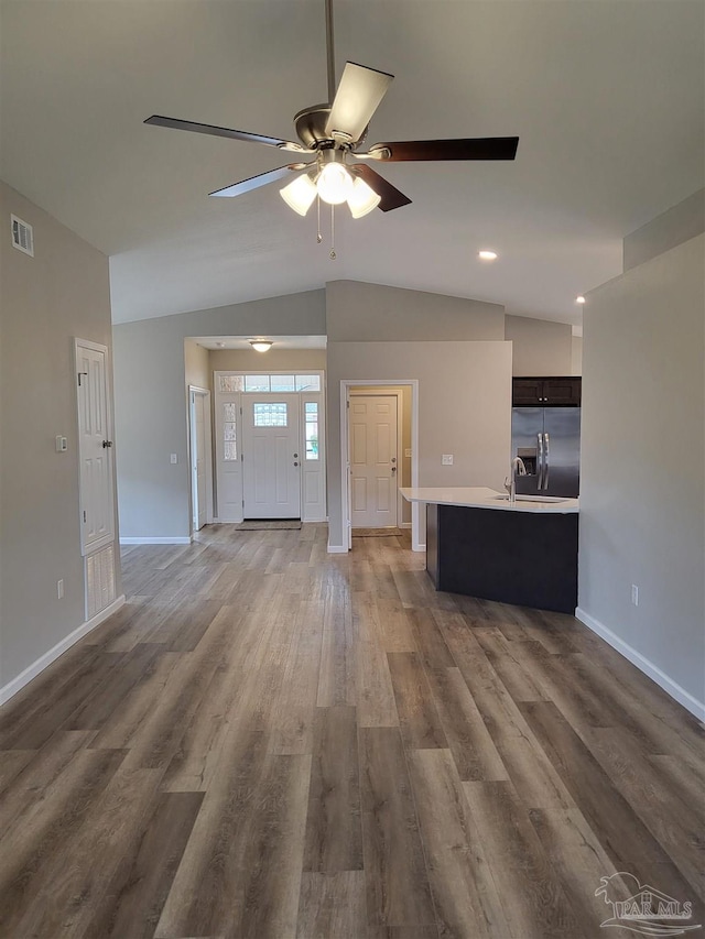 unfurnished living room with ceiling fan, lofted ceiling, and hardwood / wood-style floors