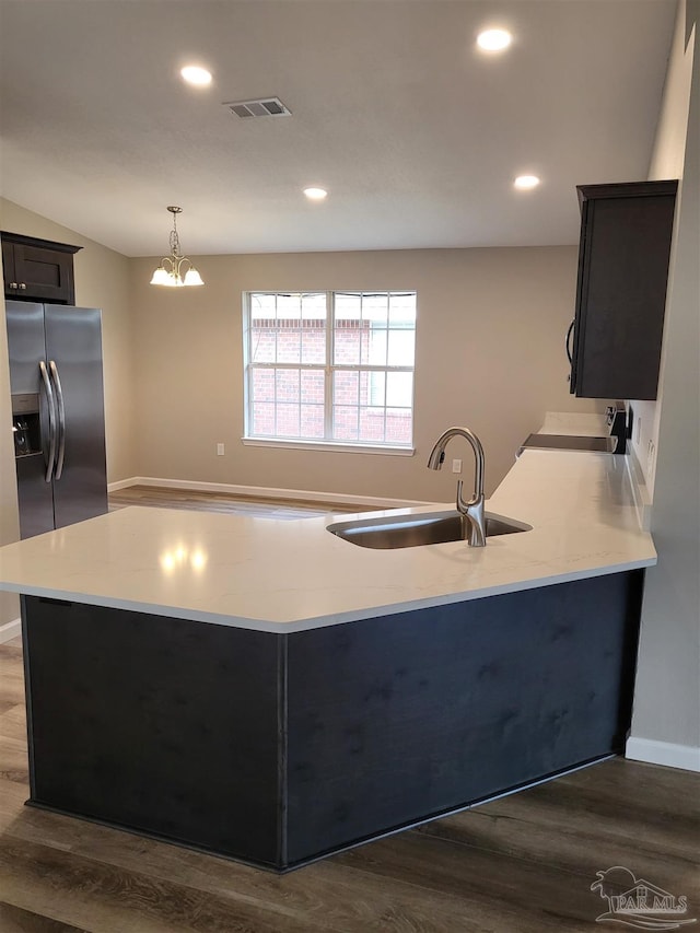 kitchen featuring sink, decorative light fixtures, dark wood-type flooring, a notable chandelier, and stainless steel fridge with ice dispenser