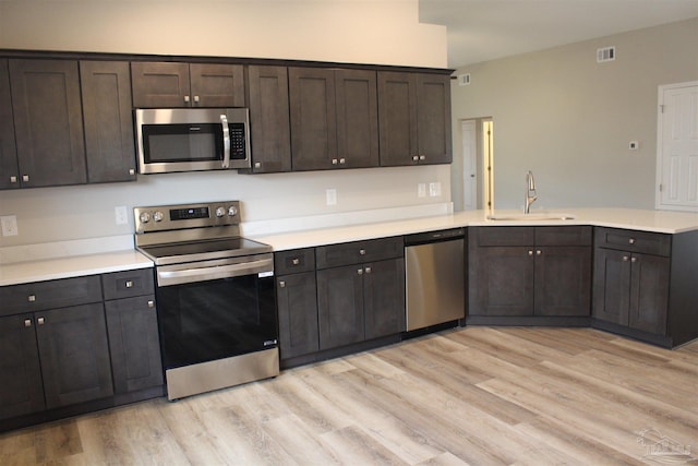 kitchen featuring light hardwood / wood-style floors, stainless steel appliances, dark brown cabinets, and sink