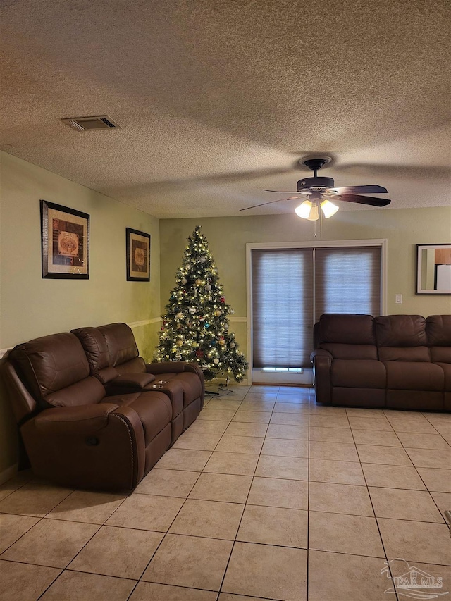 tiled living room featuring ceiling fan and a textured ceiling