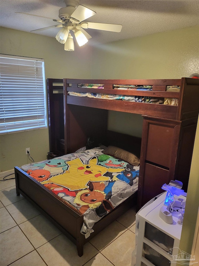 tiled bedroom with ceiling fan and a textured ceiling