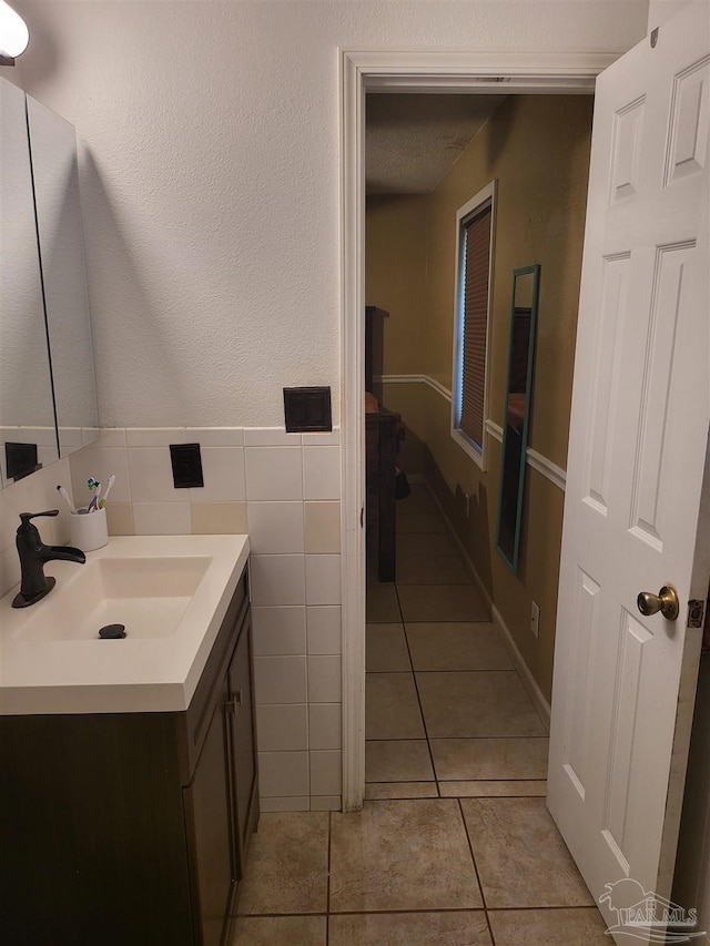 bathroom featuring tile patterned floors, vanity, and tile walls