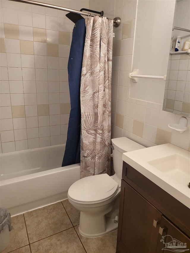 full bathroom with tile walls, vanity, toilet, shower / bathtub combination with curtain, and tile patterned floors