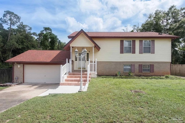 bi-level home featuring a garage and a front lawn