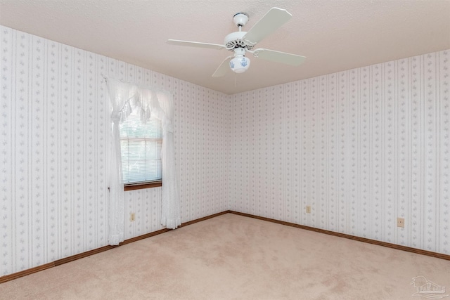 unfurnished room featuring carpet floors, a textured ceiling, and ceiling fan