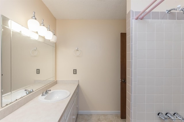 bathroom featuring walk in shower, vanity, tile patterned flooring, and a textured ceiling