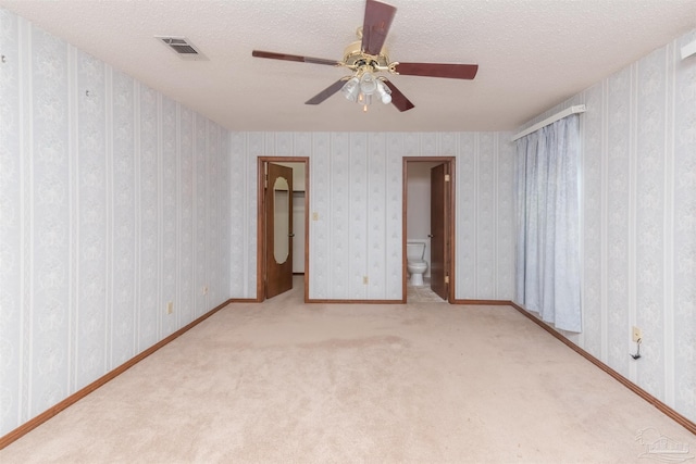 unfurnished room featuring ceiling fan, light colored carpet, and a textured ceiling