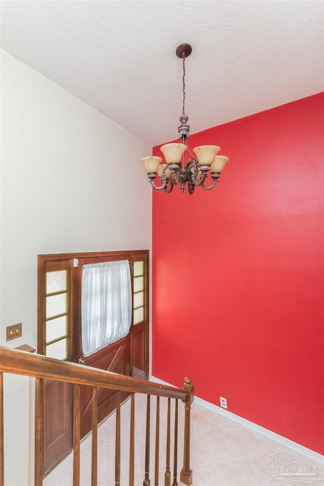 stairs with a chandelier and a textured ceiling