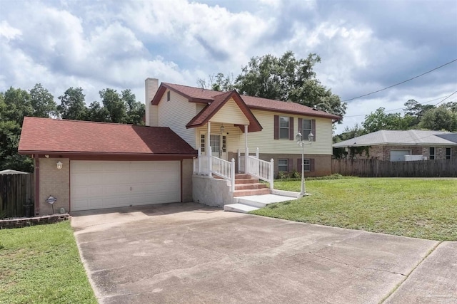 raised ranch featuring a garage and a front yard